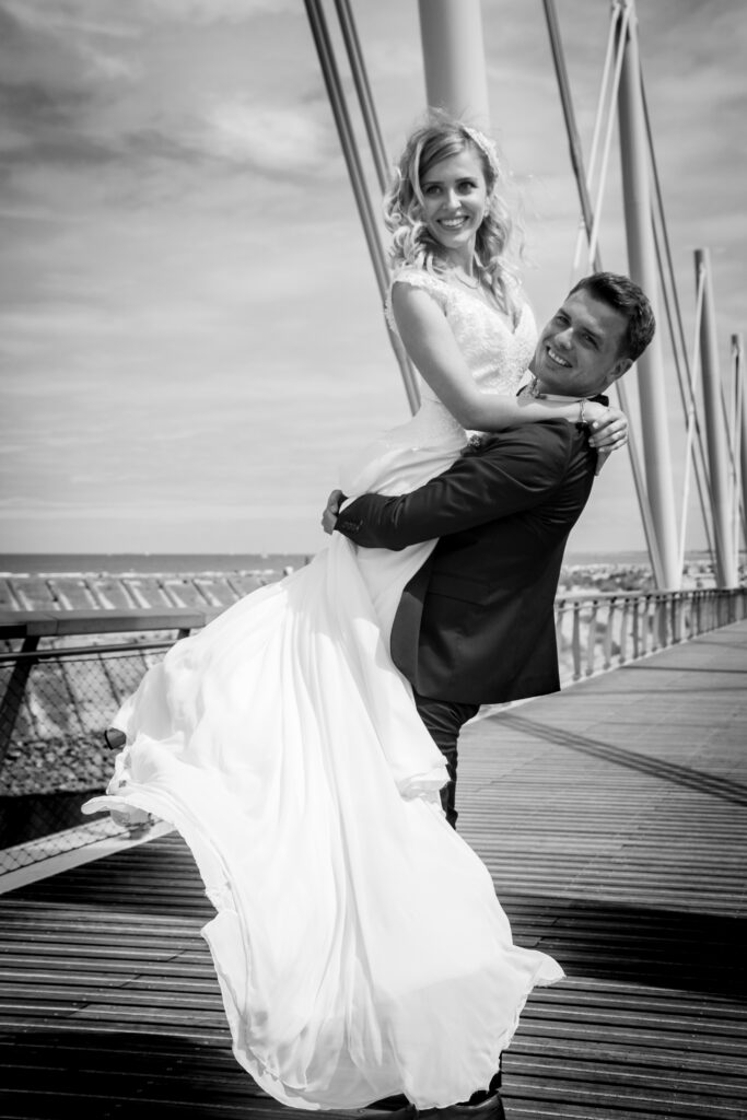 Anastasia et Julien, photo de mariage, noir et blanc, homme porte femme robe de mariée, moment de vie, anael jourdain photographe amateur lille dunkerque