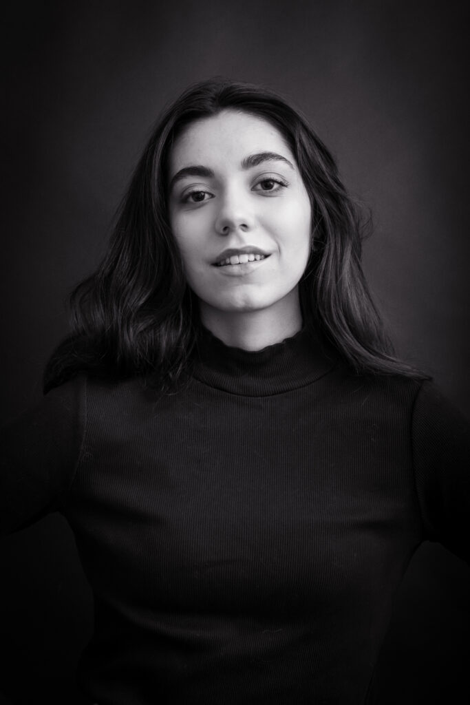 Angela, séance photo portrait studio, noir et blanc, cheveux long et bruns, regard objectif de face, sourire naturel, anael jourdain photographe amateur lille dunkerque