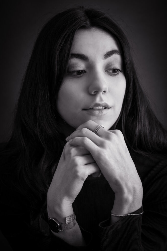 Angela, séance photo portrait studio, noir et blanc, cheveux long et bruns, mains sous le menton avec bijoux, anael jourdain photographe amateur lille dunkerque