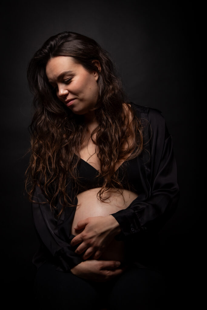 Cassandre, photo de grossesse, couleur, chemise noire, femme tient son ventre nu, portrait studio, moment de vie, anael jourdain photographe amateur lille dunkerque