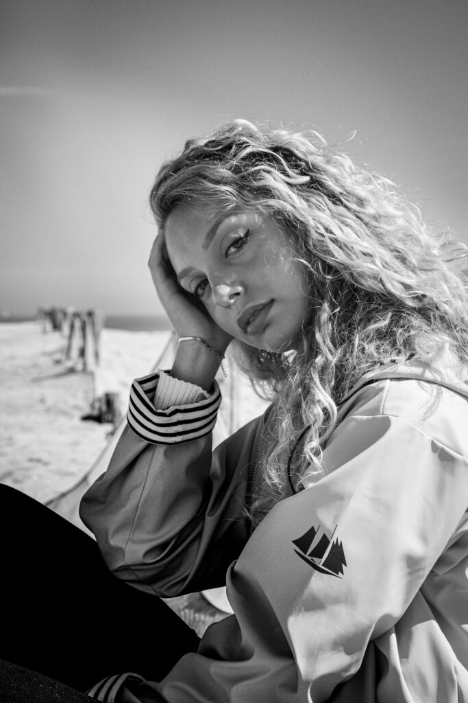 Elise, séance photo portrait extérieur noir et blanc, plage de malo les bains, ciel bleu, ciré jaune, main dans les cheveux, anael jourdain photographe amateur lille dunkerque