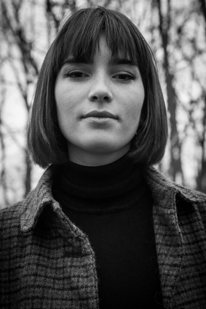 léa, photo portrait extérieur noir et blanc, nature, forêt, joli regard, veste carreaux, jean, carré frange, automne- série de photo portait réalisée par Anael Jourdain Photographe Amateur Hauts-de-France