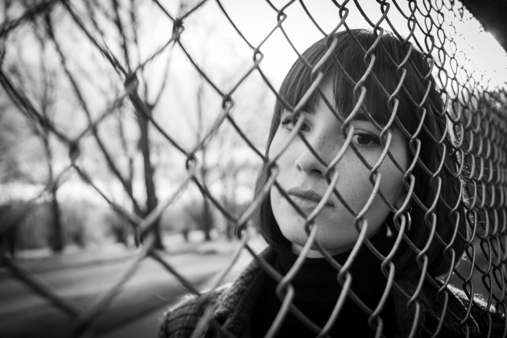 léa, photo portrait extérieur noir et blanc, natur, carré frange,automne grillage - série de photo portait réalisée par Anael Jourdain Photographe Amateur Hauts-de-France