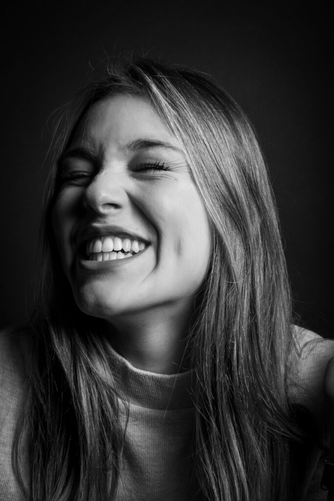 solene, photo studio noir et blanc, cheveux blond, grand sourire naturel - série de photo portait réalisée par Anael Jourdain Photographe Amateur Hauts-de-France