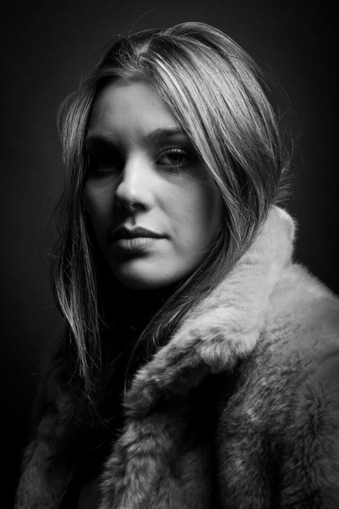 solene, photo studio noir et blanc, cheveux blond, avec une fourrure - série de photo portait réalisée par Anael Jourdain Photographe Amateur Hauts-de-France