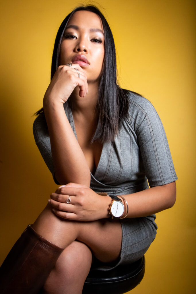 victoire, portrait studio, assise sur un tabouret robe et bottes, photo couleur format portrait - série de photo portait réalisée par Anael Jourdain Photographe Amateur Hauts-de-France